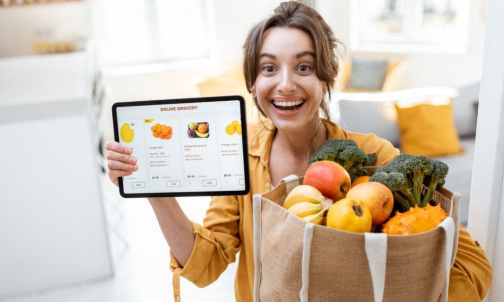 Kobieta trzyma zakupy spożywcze zamówione w sklpeie online