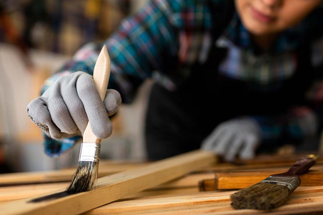 Kobieta obrabia drewno w warsztacie