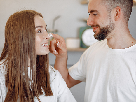 mężczyzna kremuje twarz kobiecie