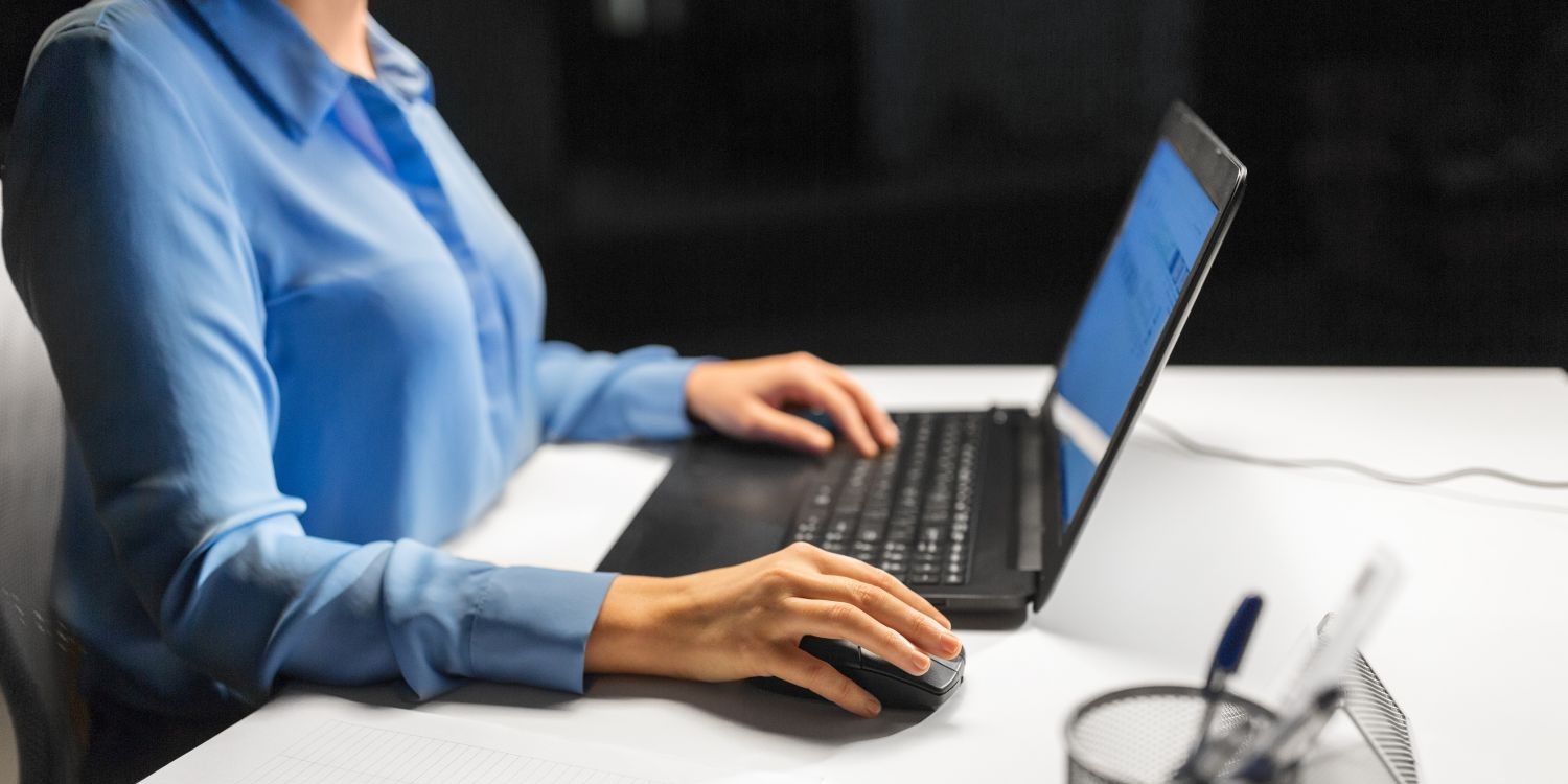 Kobieta korzystająca z laptopa i myszki