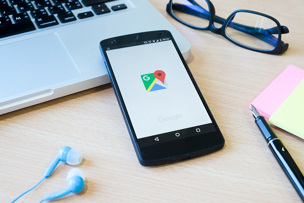biurko z laptopem i telefonem z mapami Google